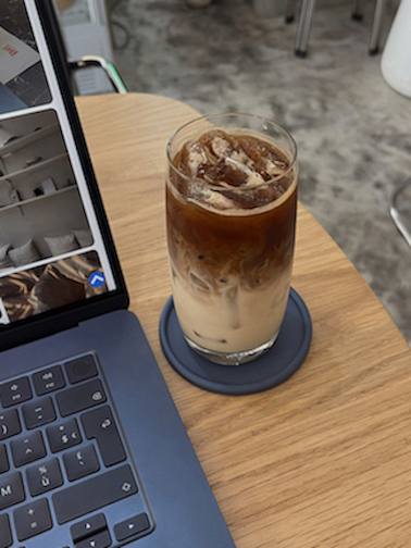 Iced coffee next to laptops.
