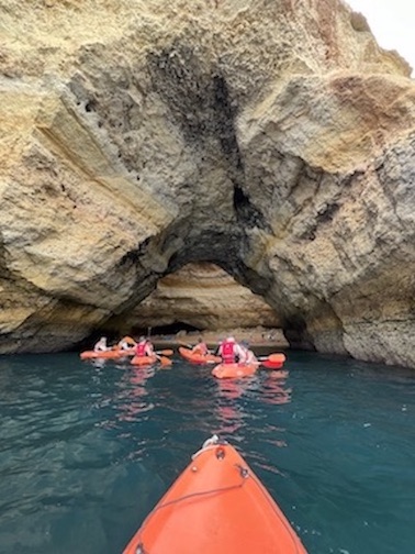 View of kayakers under a cave.